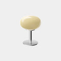 Elegant macaron-inspired table lamp with a soft yellow shade on a sleek metal base, perfect for any modern décor.